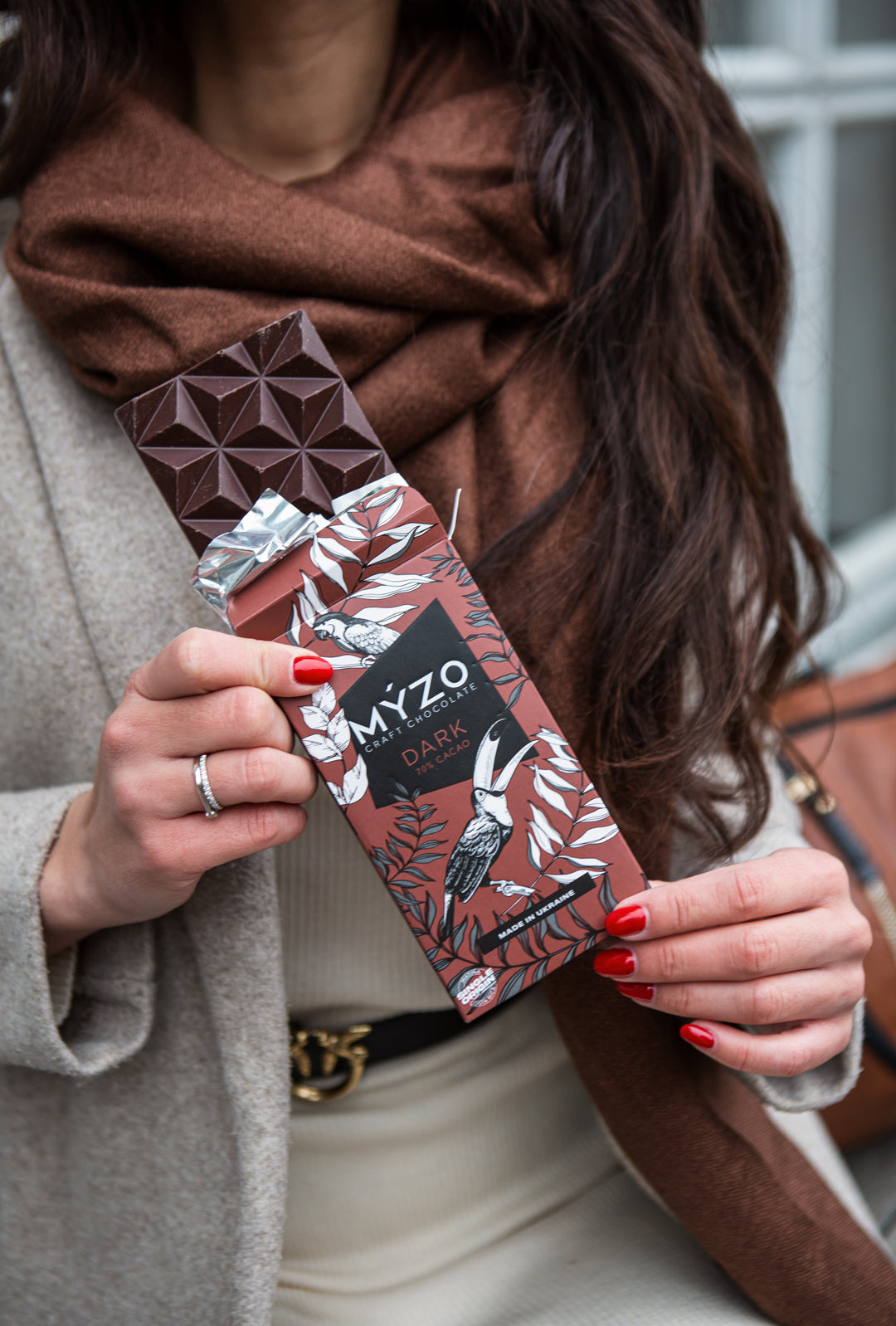 Дівчина тримає плитку темного шоколаду Myzo Dark