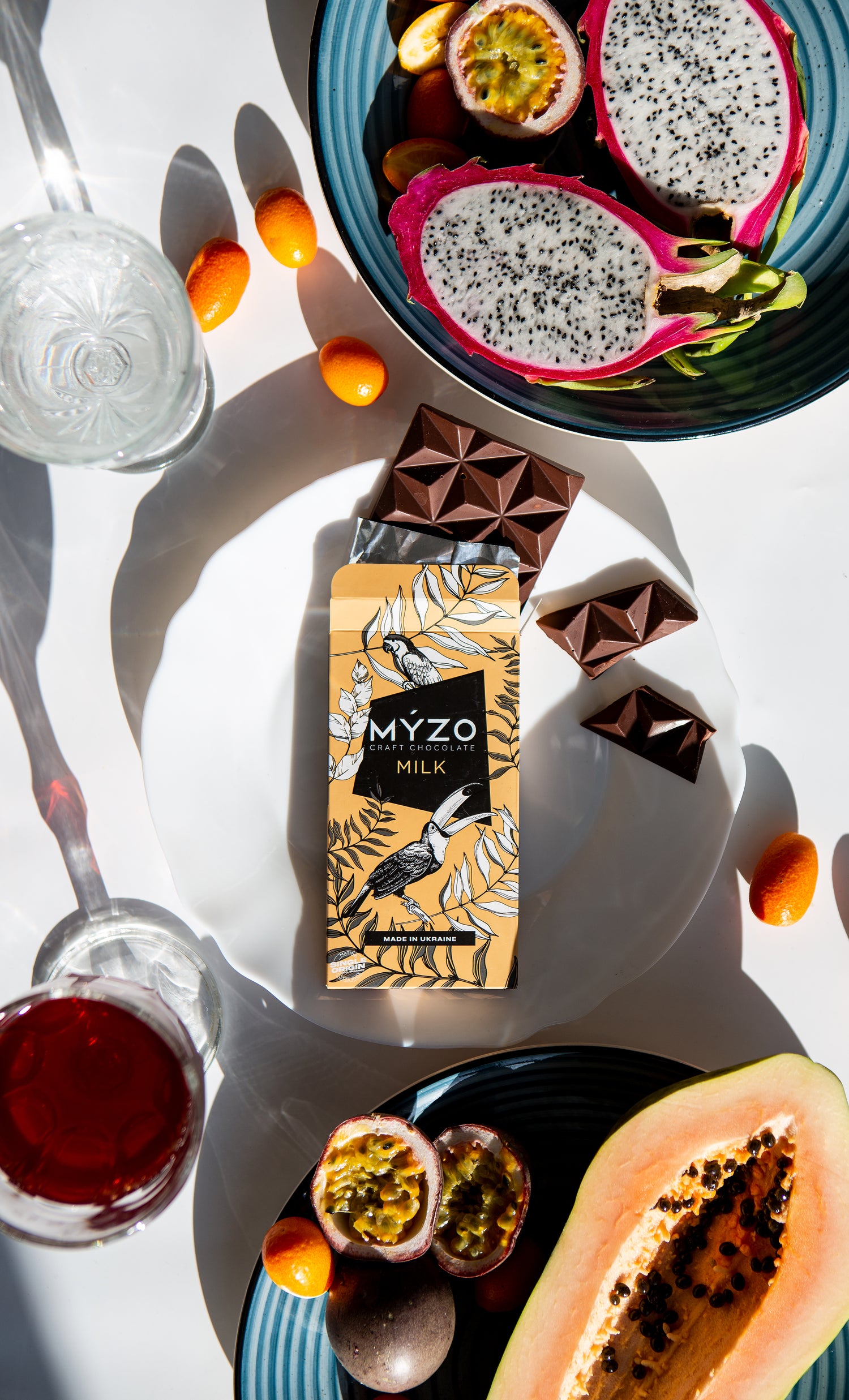 Шоколад Myzo 48% молочний лежить на столі з фруктами