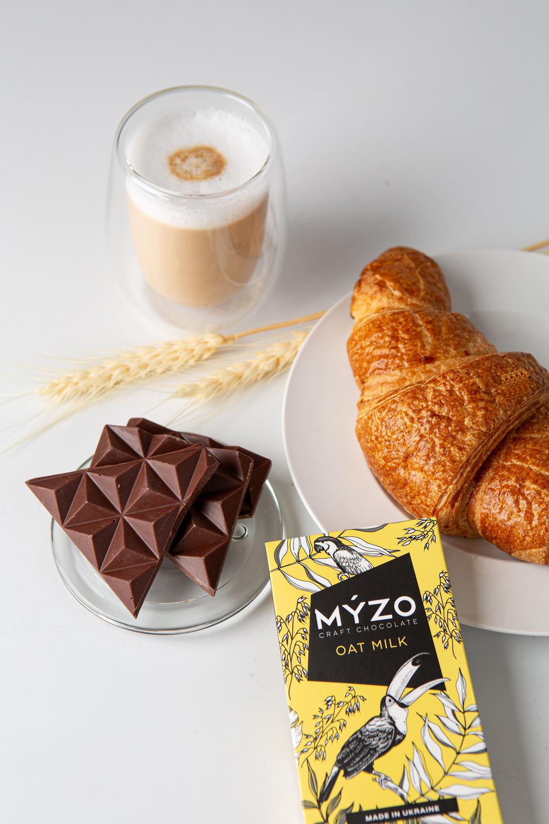 Крафтовий шоколад Myzo з вівсяним толокном на столі з круасаном та кавою